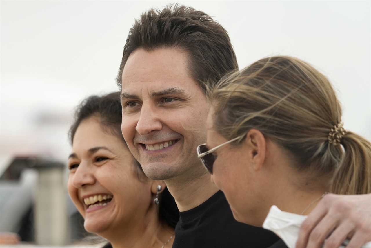 Michael Kovrig, centre, embraces his wife Vina Nadjibulla, left, and sister Ariana Botha after arriving at Pearson International Airport in Toronto, Saturday, Sept. 25, 2021. (Frank Gunn/Canadian Press)