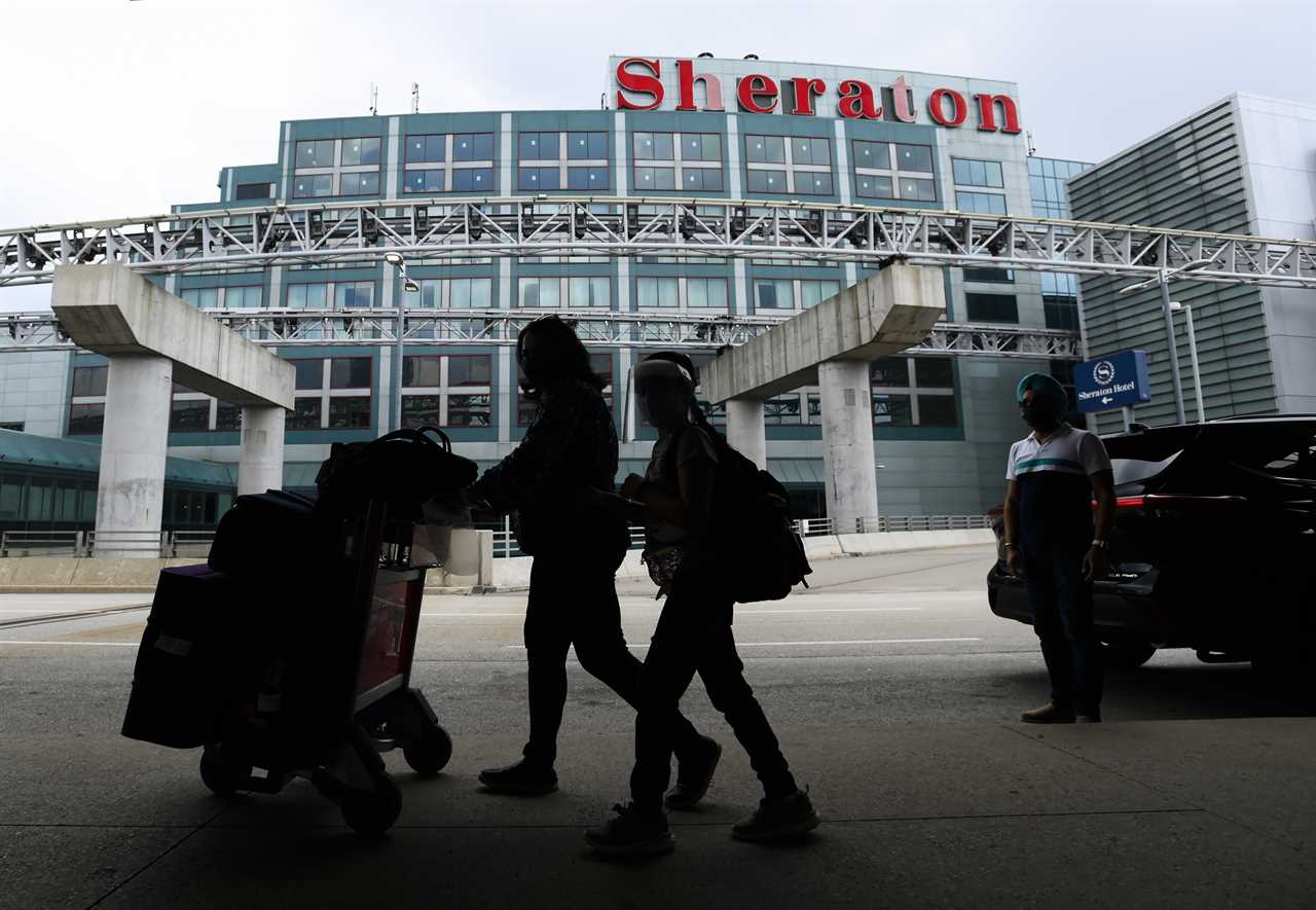 People walk with their luggage to travel to the United States during the COVID-19 pandemic in Toronto on Wednesday, June 9, 2021. THE CANADIAN PRESS/Nathan Denette