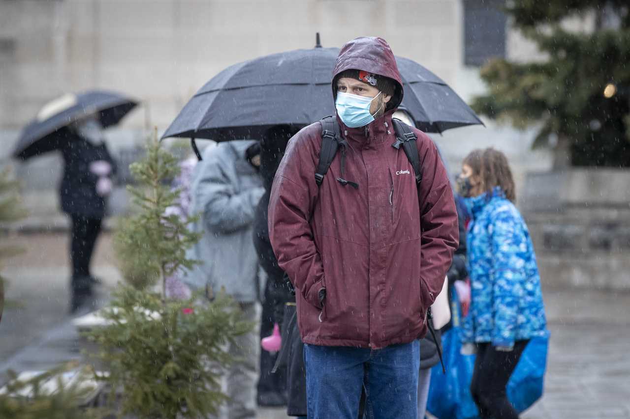 A person waits in line during a COVID-19 vaccine clinic in Kingston, Ontario on Dec. 15, 2021. (Lars Hagberg/The Canadian Press)