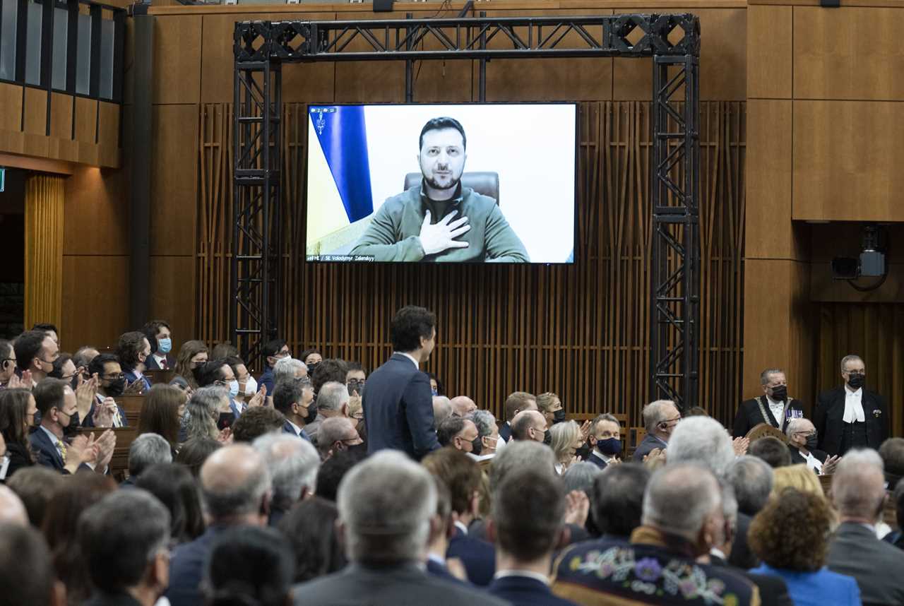 Zelensky places his hand on his chest as he listens to Canadian Prime Minister Justin Trudeau deliver opening remarks before addressing the Canadian parliament, March 15, 2022 in Ottawa. (Adrian Wyld/The Canadian Press)