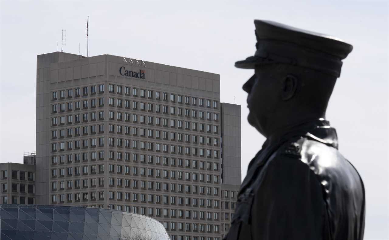 A statue of General Arthur Currie looks towards a National Defence building, March 30, 2022 in Ottawa. (Adrian Wyld/The Canadian Press)