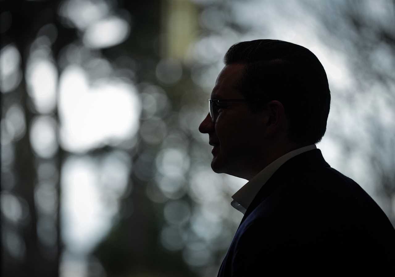 Poilievre is silhouetted during a meet and greet at the University of British Columbia, in Vancouver, April 7, 2022. (Darryl Dyck/The Canadian Press)