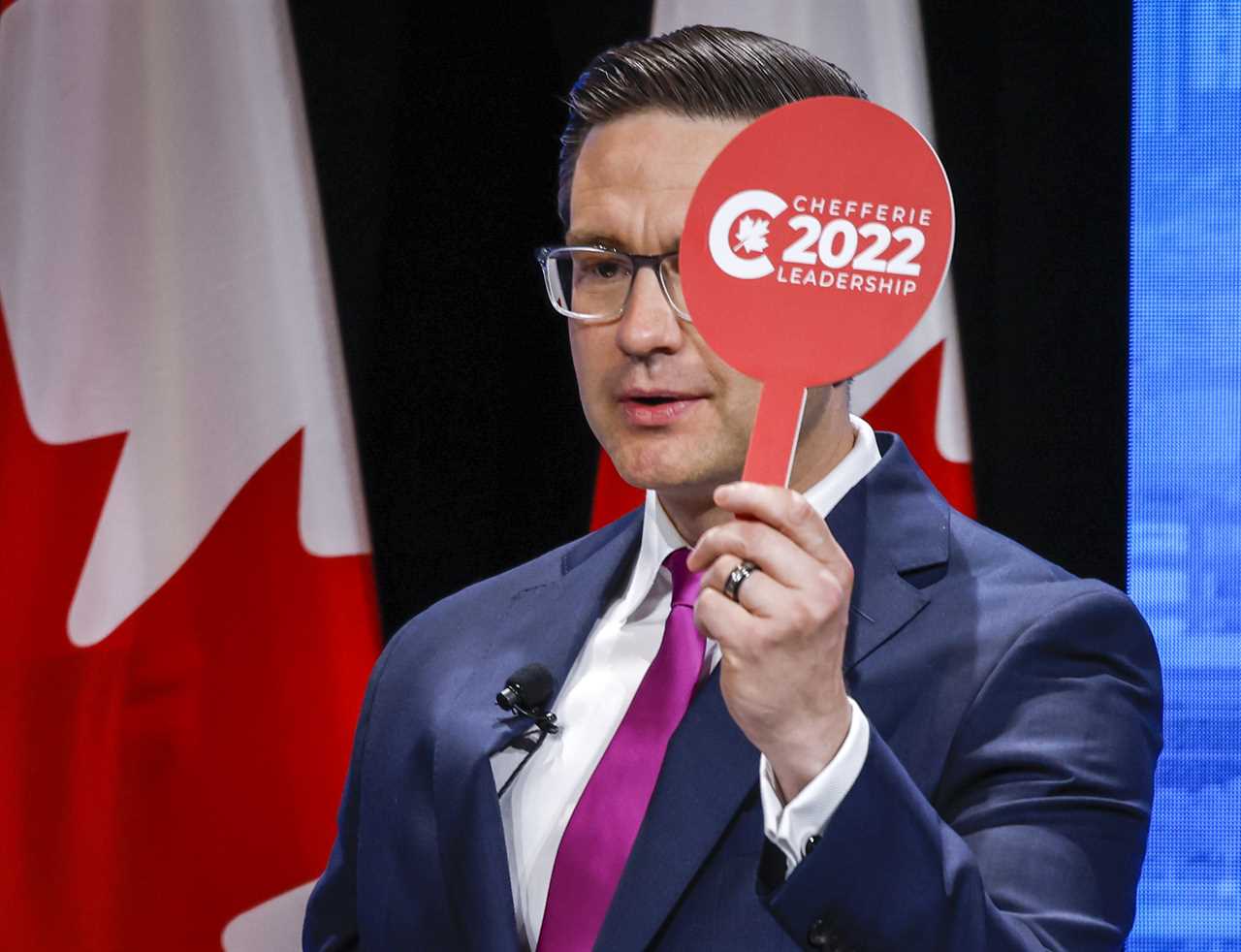 Pierre Poilievre holds his "intervention paddle" at the Conservative Party of Canada English leadership debate in Edmonton, Alta., May 11, 2022. (Jeff McIntosh/The Canadian Press)