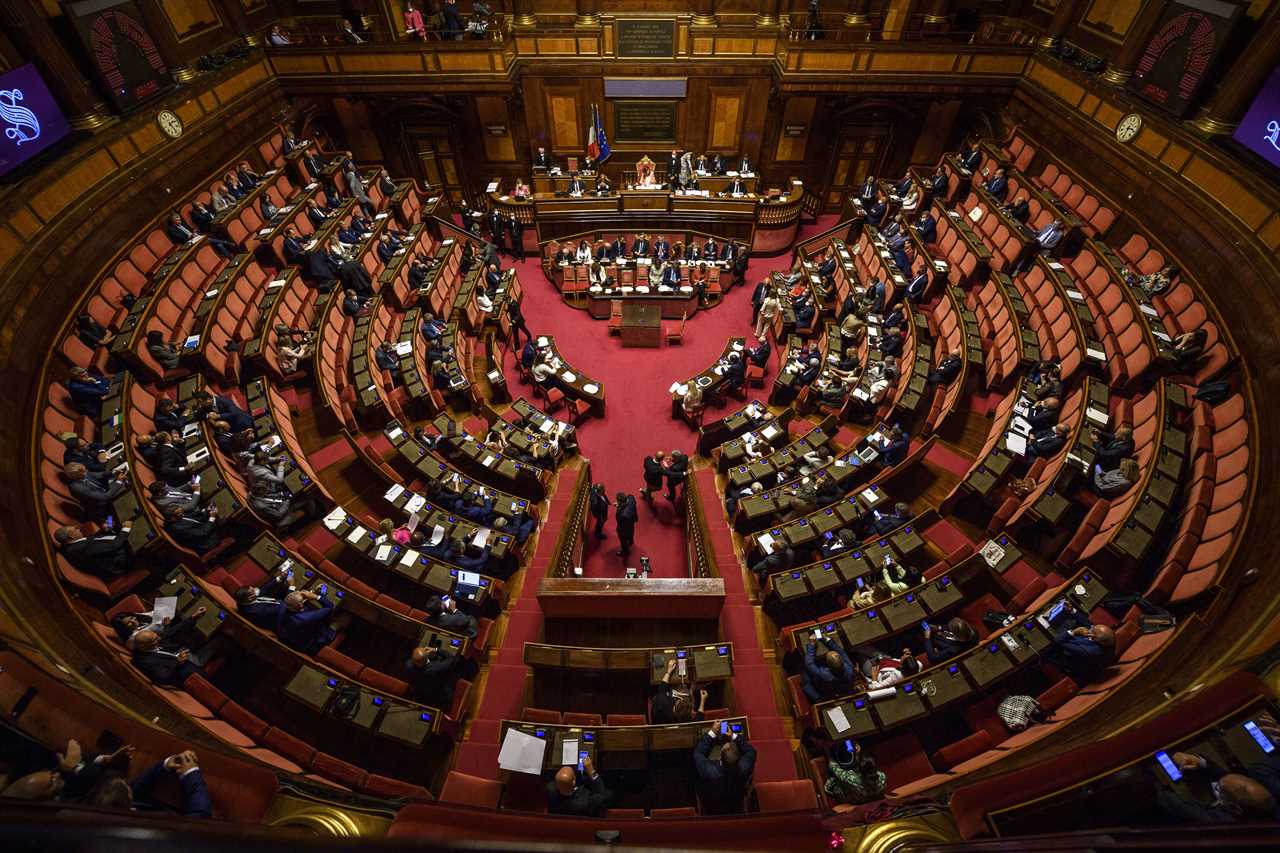 An aerial shot shows the Italian parliament with circular seating.